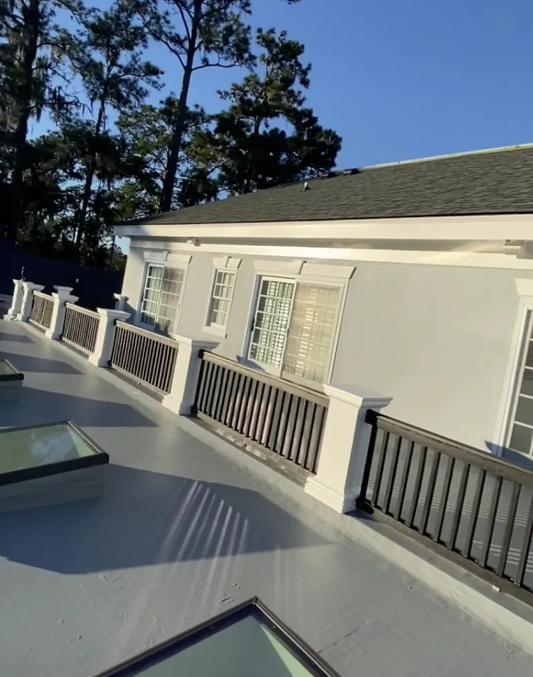 Rooftop deck and dormer trim freshly painted white on a coastal home