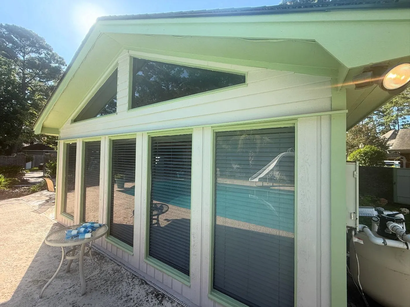 Screened porch and gable roofline freshly painted with sage green trim