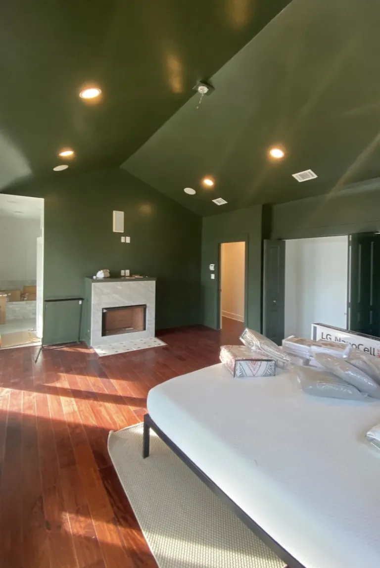 Bedroom with a freshly painted deep olive vaulted ceiling