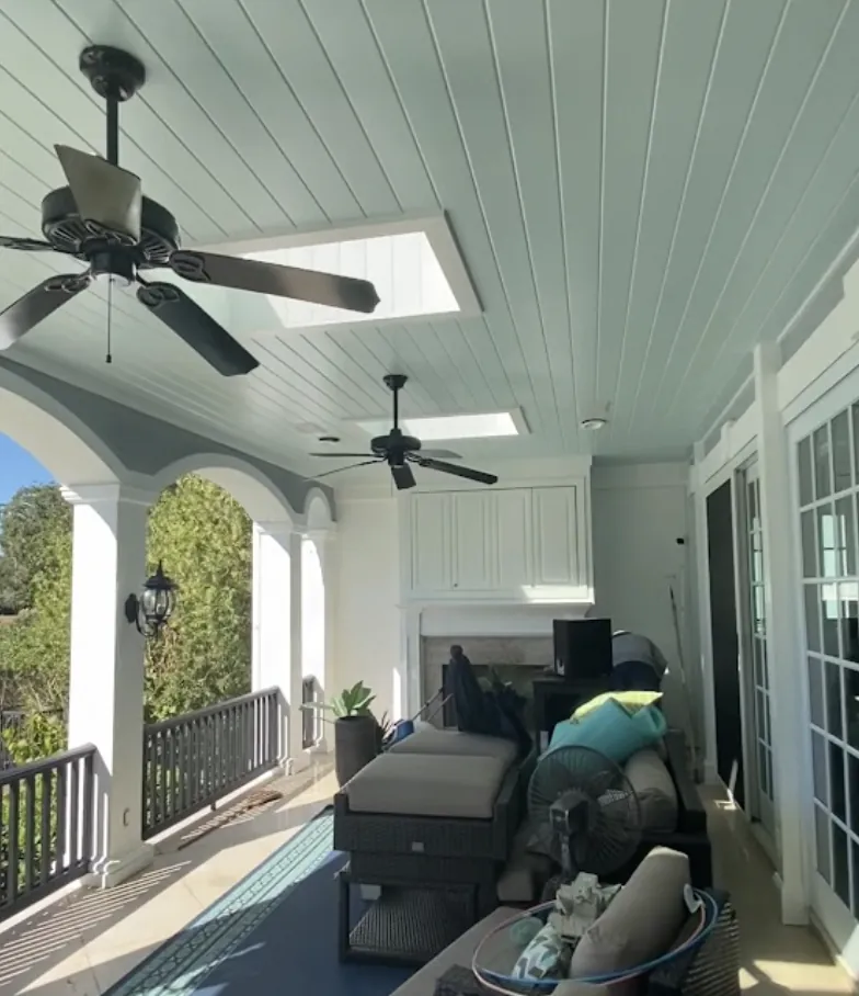 Covered porch with a traditional haint blue painted ceiling and stained deck floor